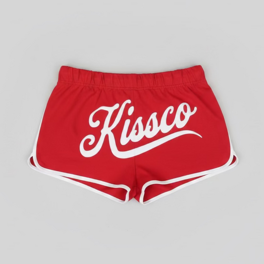 Red shorts with 'Kissco' logo on a black and white checkered floor